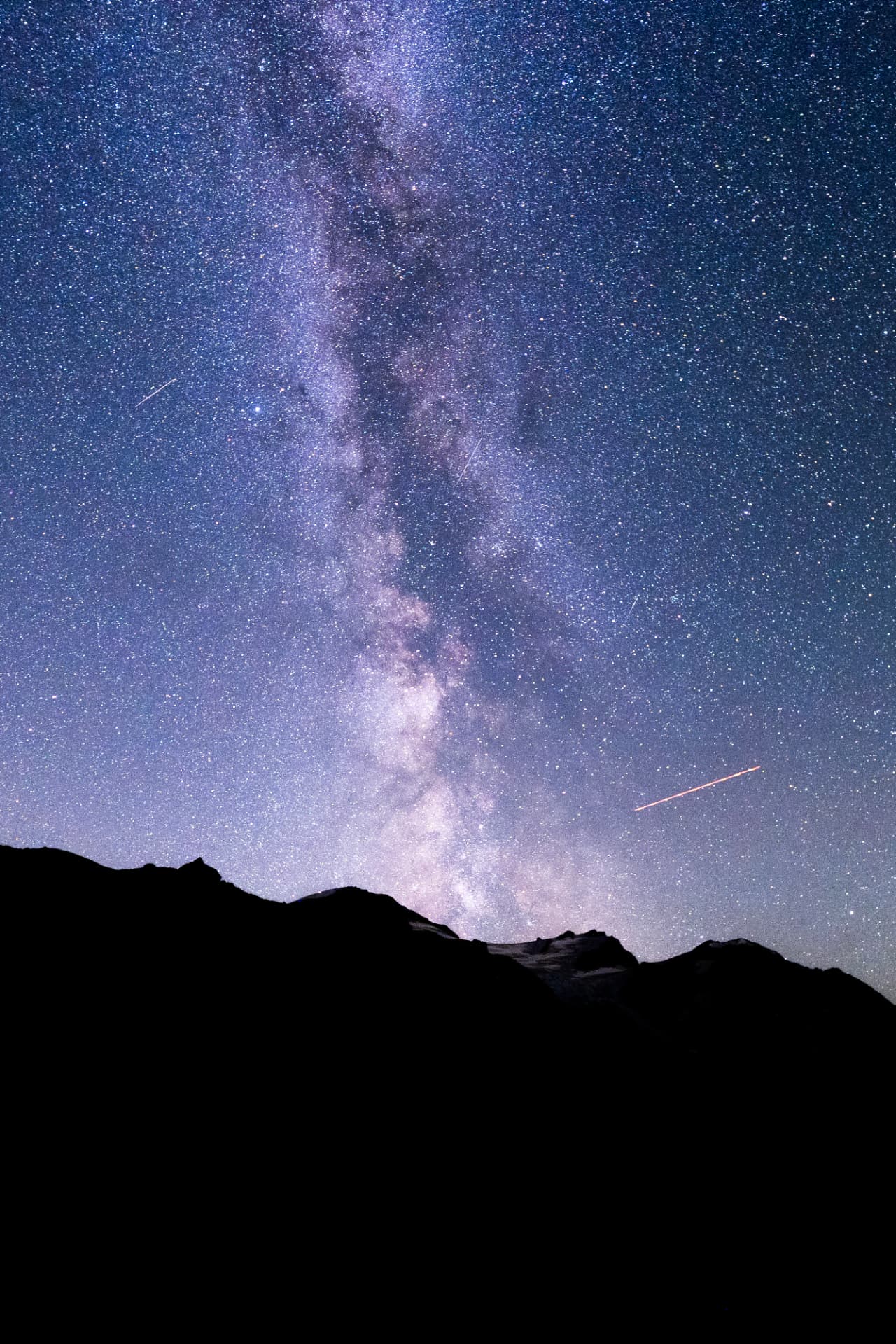 Milky Way over a dark mountain silhouette at night