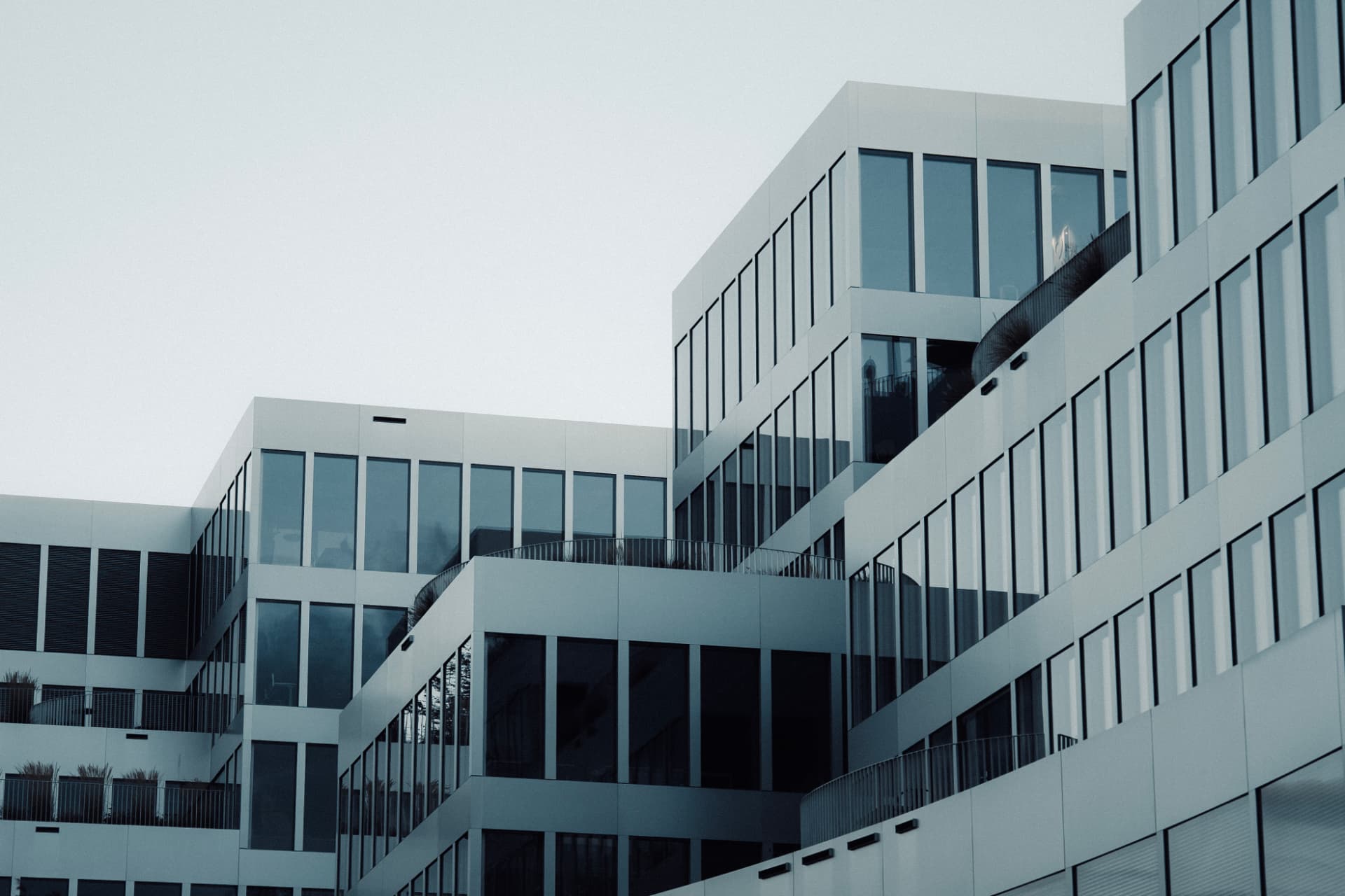 Stacked modern glass facade against a pale sky